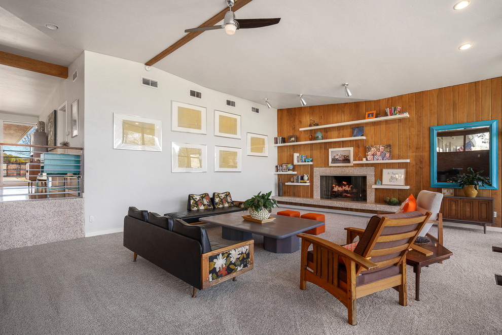 Photo of an expansive retro formal open plan living room in Albuquerque with white walls, carpet, a standard fireplace, a concrete fireplace surround and beige floors.