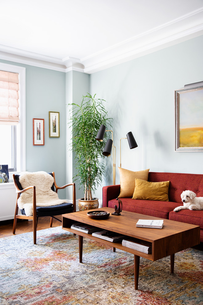 Aménagement d'un salon rétro de taille moyenne et fermé avec un mur bleu, un sol en bois brun et un sol marron.