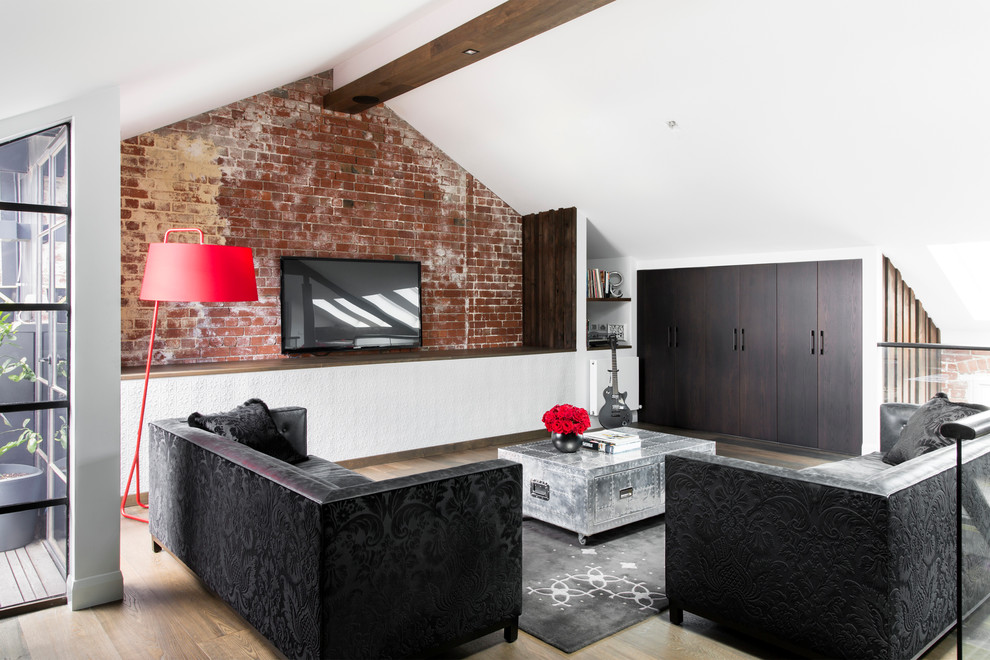 Foto de salón para visitas tipo loft urbano grande con paredes blancas, suelo de madera en tonos medios y televisor colgado en la pared