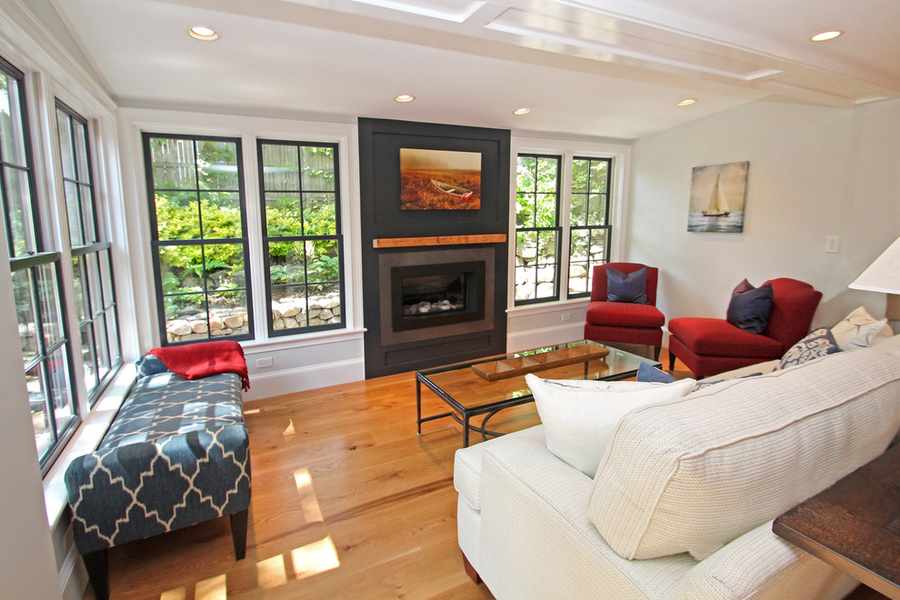 Medium sized contemporary formal enclosed living room in Boston with grey walls, medium hardwood flooring, a standard fireplace, a wooden fireplace surround and brown floors.