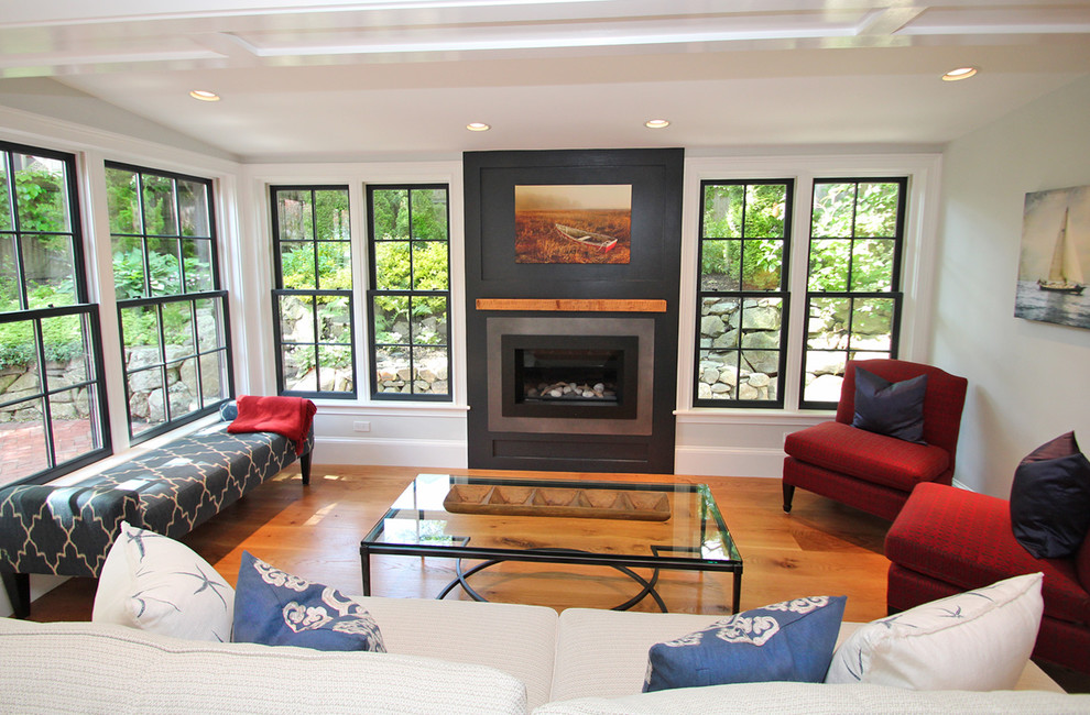 Mid-sized trendy enclosed and formal medium tone wood floor and brown floor living room photo in Boston with white walls, a standard fireplace and a concrete fireplace