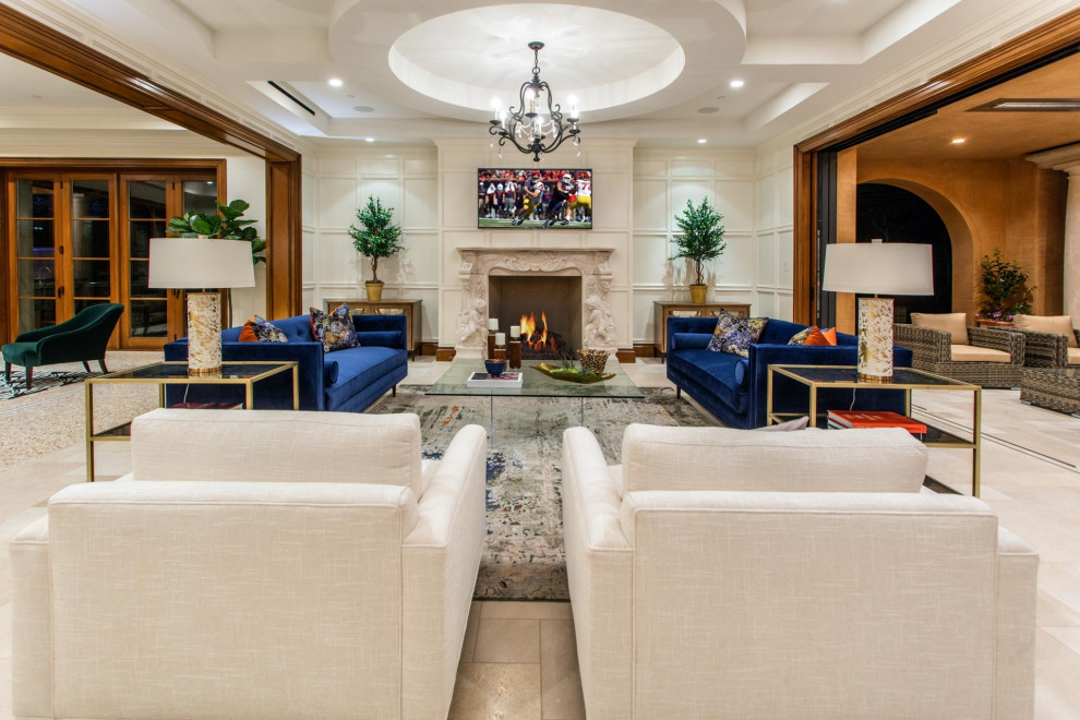 Example of a large tuscan open concept marble floor and beige floor living room design in Orange County with white walls, a standard fireplace, a stone fireplace and a wall-mounted tv