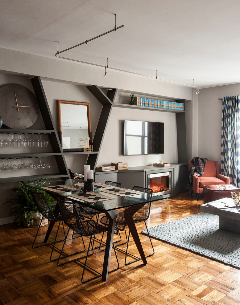 Cette image montre un salon design de taille moyenne et ouvert avec un mur gris, un sol en bois brun, un téléviseur fixé au mur, une cheminée ribbon et un manteau de cheminée en métal.