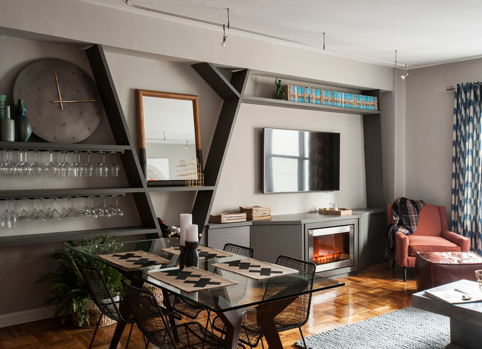 Cette photo montre un salon tendance de taille moyenne et ouvert avec un bar de salon, un mur gris, un sol en bois brun, cheminée suspendue, un manteau de cheminée en bois et un téléviseur fixé au mur.