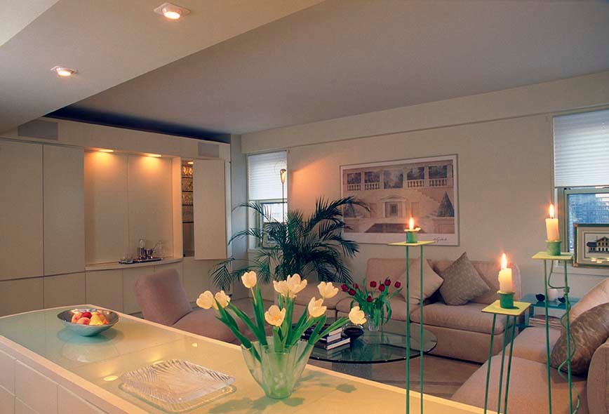 Foto di un ampio soggiorno moderno stile loft con pareti beige, parquet chiaro e TV nascosta