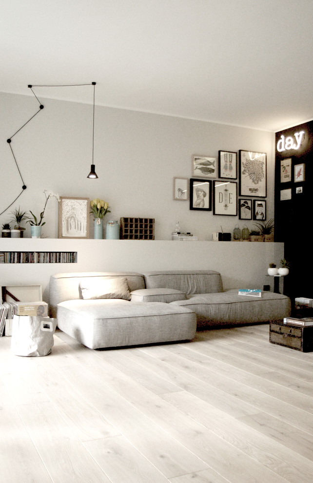Industrial Wohnzimmer mit braunem Holzboden und grauer Wandfarbe in Mailand