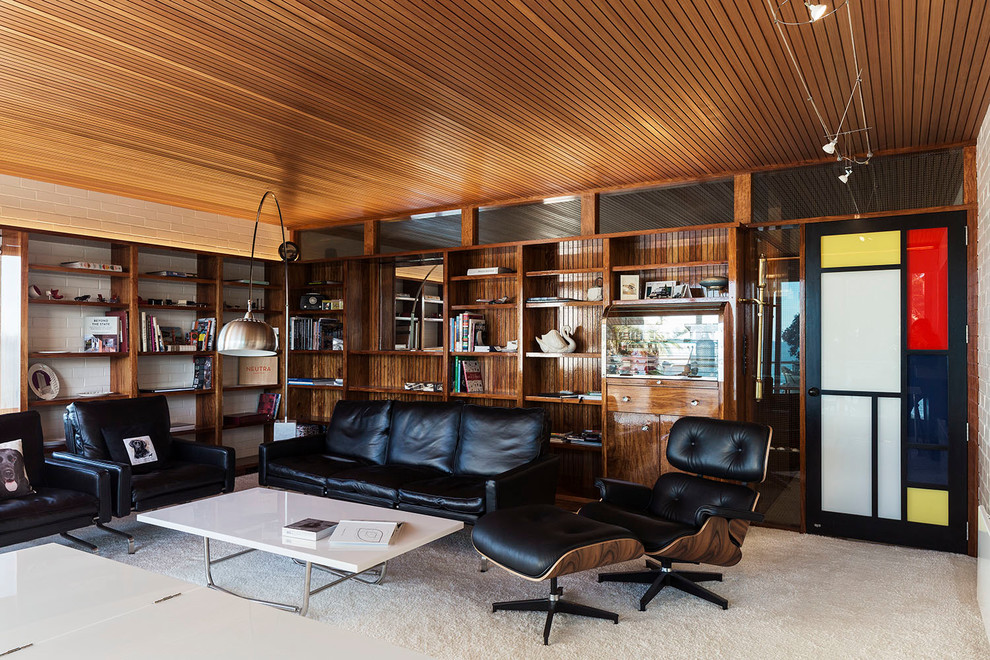 Inspiration for a mid-sized mid-century modern open concept carpeted and white floor living room library remodel in Auckland with white walls and a concealed tv