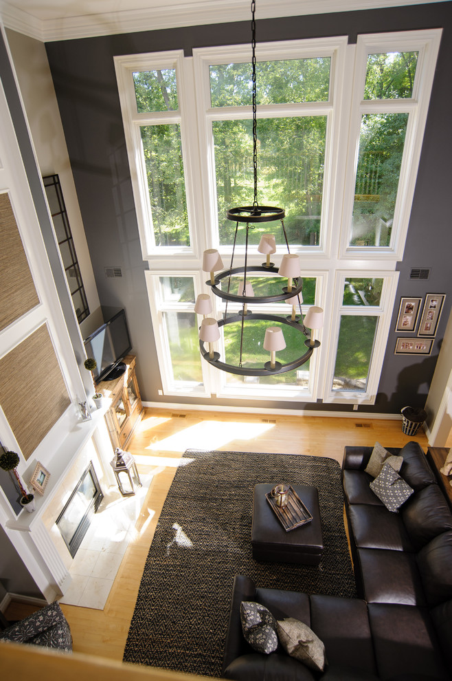 Свежая идея для дизайна: открытая гостиная комната среднего размера в стиле неоклассика (современная классика) с серыми стенами, светлым паркетным полом, фасадом камина из плитки и отдельно стоящим телевизором - отличное фото интерьера