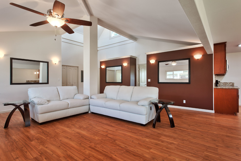 Réalisation d'un grand salon minimaliste ouvert avec un mur blanc et un sol en bois brun.