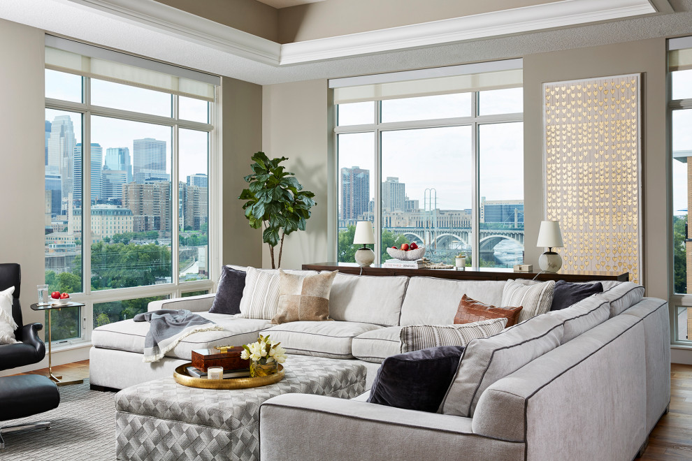 Immagine di un grande soggiorno tradizionale aperto con pareti beige, pavimento in legno massello medio e TV a parete