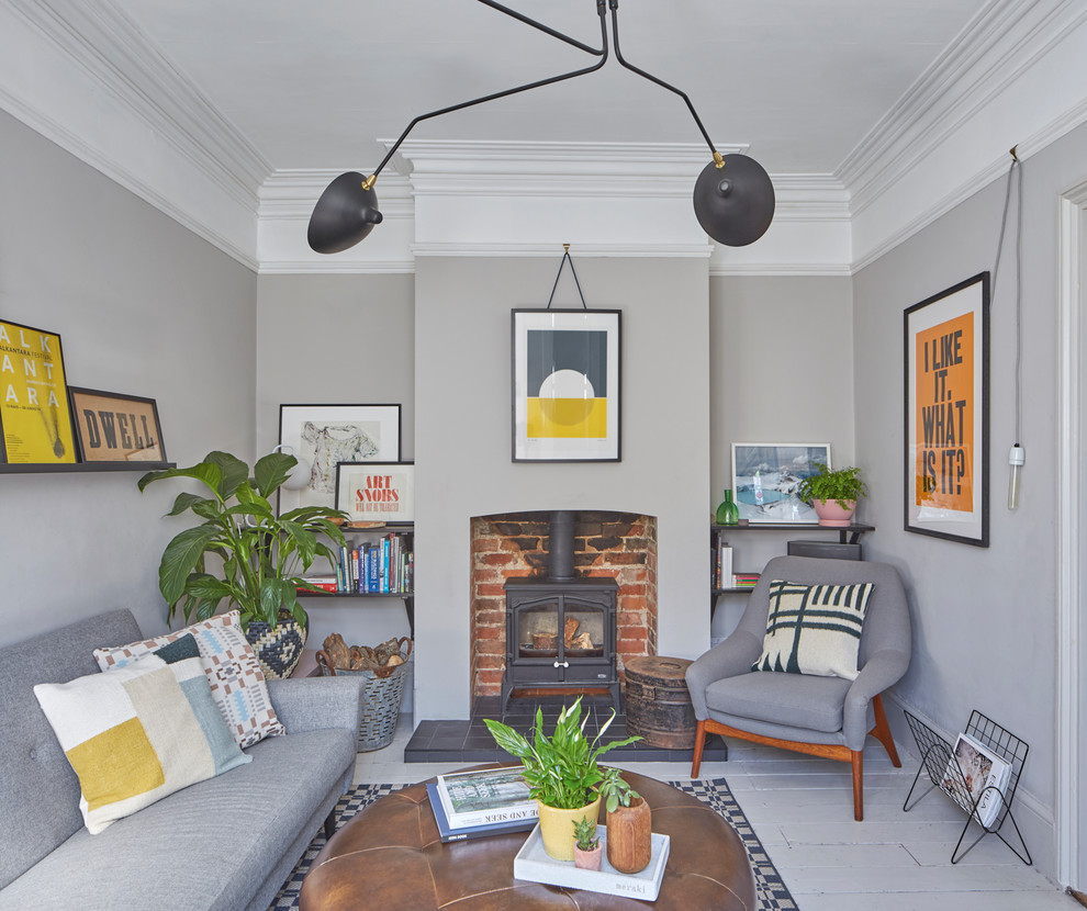 Example of a danish painted wood floor and gray floor living room library design in Essex with gray walls and a wood stove