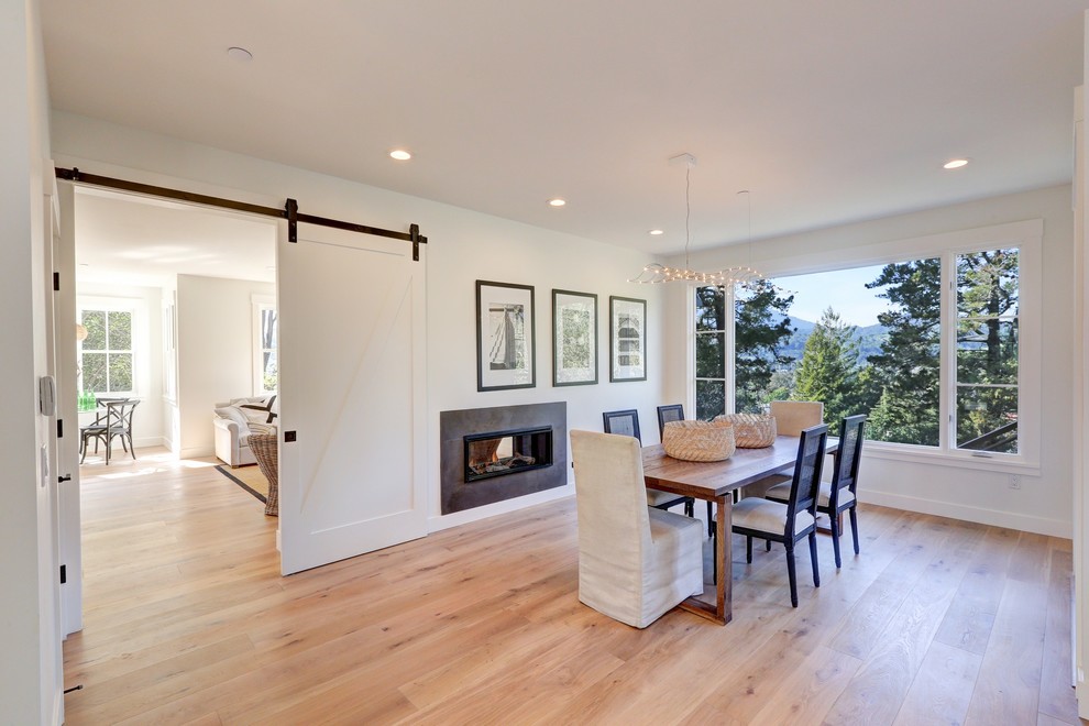 Landhaus Wohnzimmer mit weißer Wandfarbe, hellem Holzboden, Tunnelkamin, gefliester Kaminumrandung und Multimediawand in San Francisco