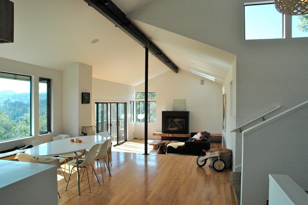 Идея дизайна: двухуровневая гостиная комната среднего размера в стиле модернизм с белыми стенами, светлым паркетным полом и фасадом камина из кирпича без телевизора