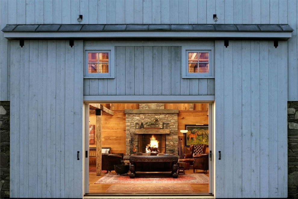 Inspiration for a large rural open plan living room in New York with medium hardwood flooring, a standard fireplace, a stone fireplace surround, no tv and brown floors.