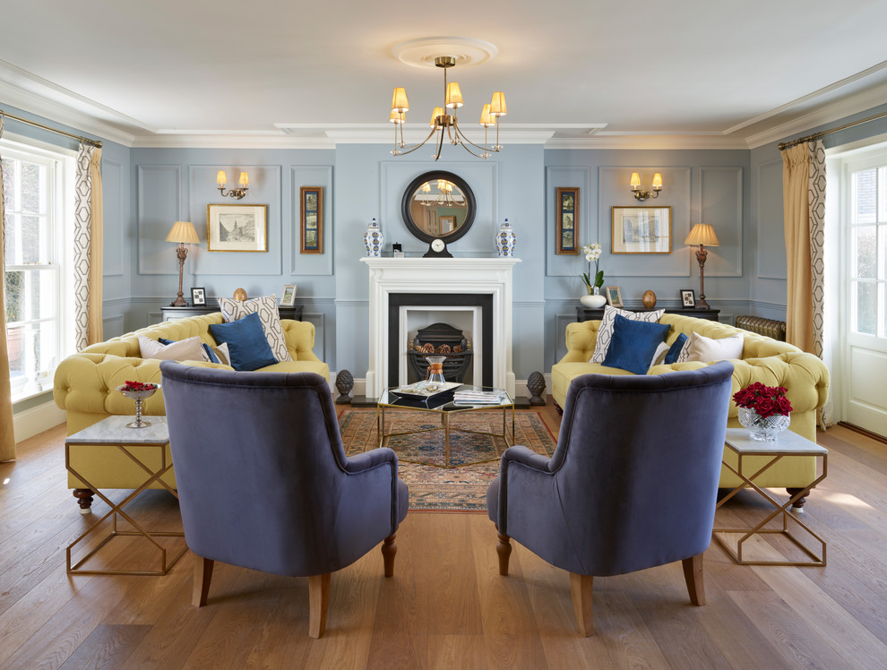Пример оригинального дизайна: изолированная, парадная гостиная комната в классическом стиле с синими стенами, коричневым полом, паркетным полом среднего тона и стандартным камином без телевизора