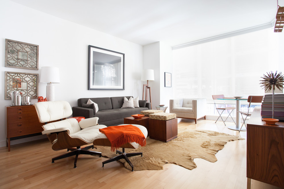 Immagine di un soggiorno minimal con sala formale, pareti bianche, parquet chiaro e TV a parete