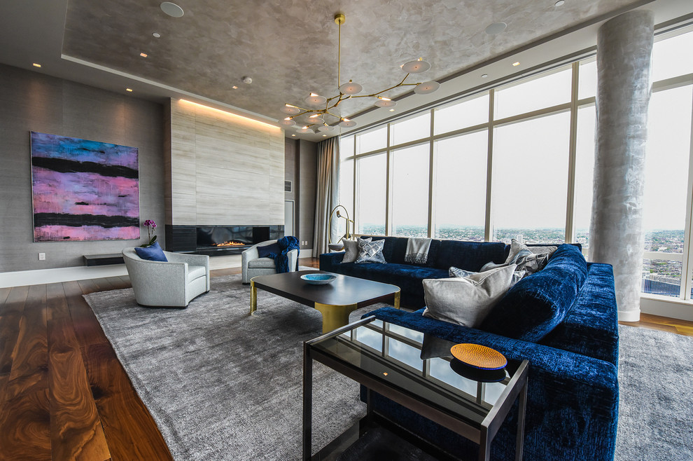 Свежая идея для дизайна: парадная, открытая гостиная комната в современном стиле с серыми стенами, темным паркетным полом, горизонтальным камином, коричневым полом и синим диваном - отличное фото интерьера