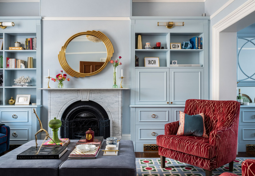 Cette photo montre un salon chic avec une bibliothèque ou un coin lecture, un mur bleu, parquet foncé, une cheminée standard et aucun téléviseur.