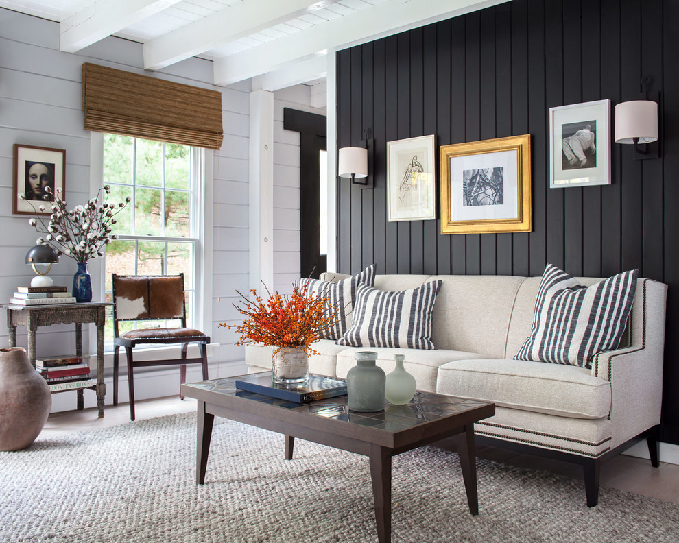 Photo of a rural living room in New York with black walls, dark hardwood flooring and brown floors.