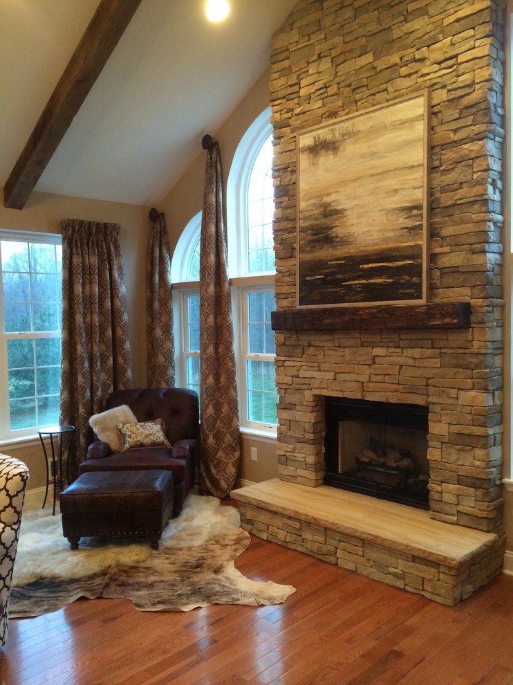 Inspiration for a medium sized rustic enclosed living room in New York with beige walls, medium hardwood flooring, a standard fireplace, a stone fireplace surround and a built-in media unit.