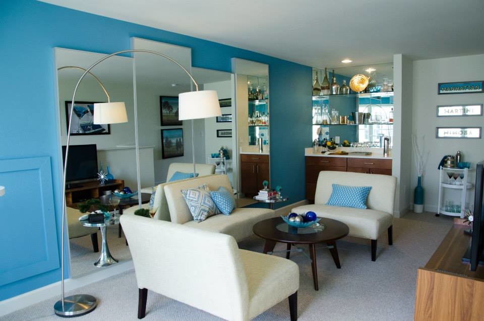 Cette image montre un salon marin avec un mur bleu et moquette.
