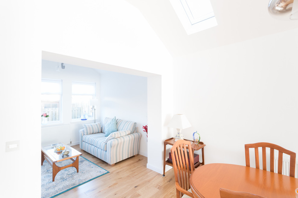 Modelo de salón para visitas abierto clásico pequeño con paredes blancas y suelo de madera clara