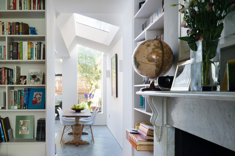 Mittelgroßes, Offenes Modernes Wohnzimmer mit weißer Wandfarbe, Betonboden, Kamin und Kaminumrandung aus Stein in London