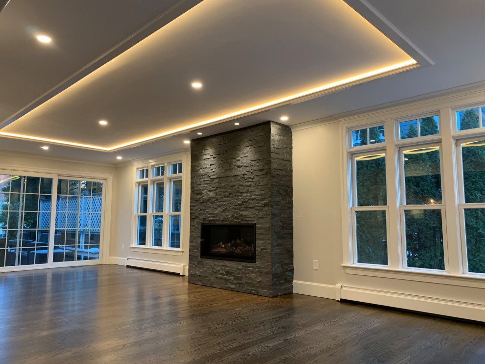 Photo of a large classic formal enclosed living room in Boston with grey walls, dark hardwood flooring, a standard fireplace, a stone fireplace surround, no tv and brown floors.