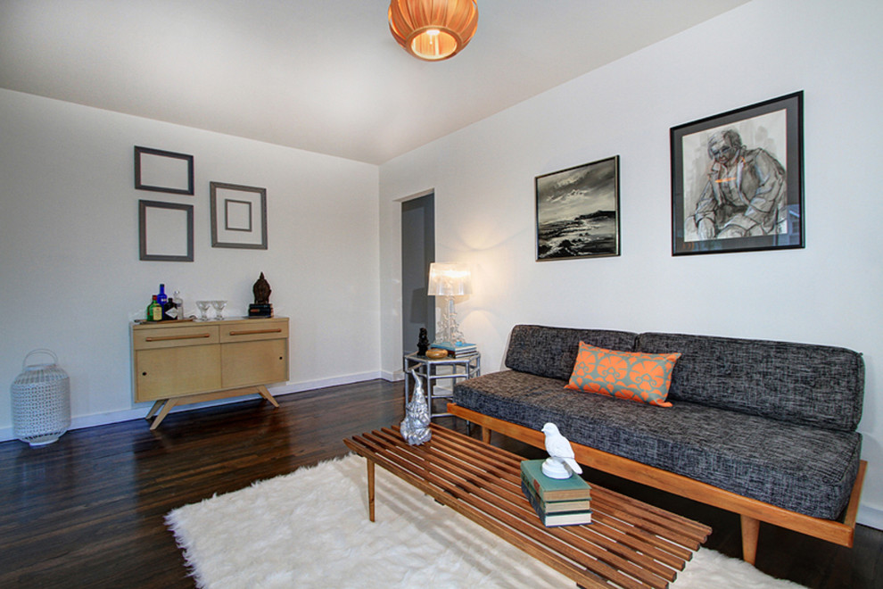 Example of a minimalist enclosed dark wood floor living room design in Los Angeles with white walls