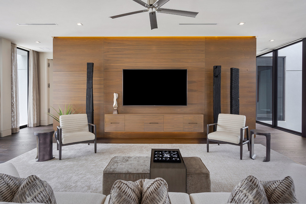 На фото: гостиная комната в современном стиле с темным паркетным полом, телевизором на стене и коричневым полом