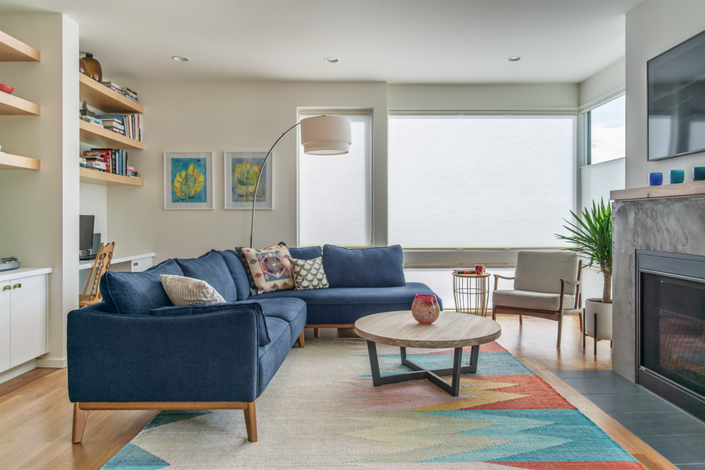 Mittelgroßes, Offenes Modernes Wohnzimmer mit weißer Wandfarbe, hellem Holzboden, Kamin und Kaminumrandung aus Beton in Seattle