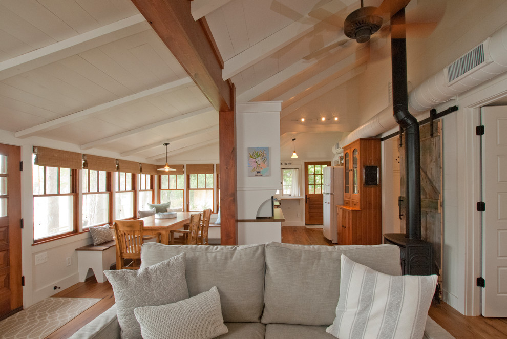 Esempio di un soggiorno stile marino con pareti bianche, pavimento in legno massello medio e stufa a legna