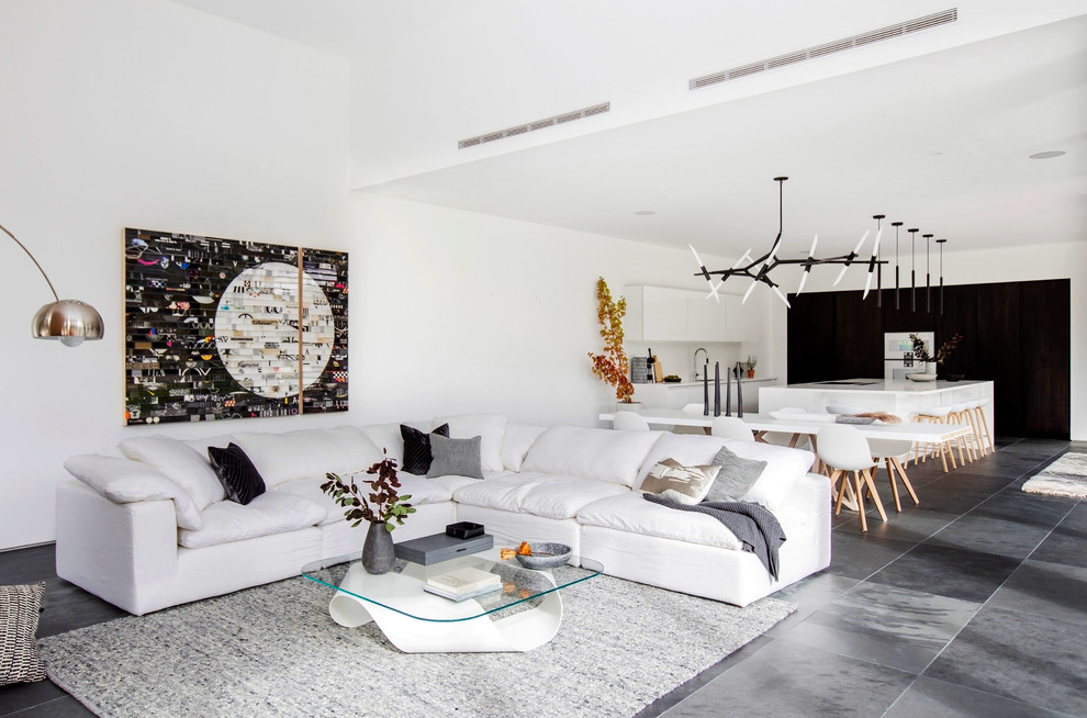 Cette photo montre un grand salon tendance ouvert avec un mur blanc, un sol en ardoise, aucun téléviseur et un sol gris.