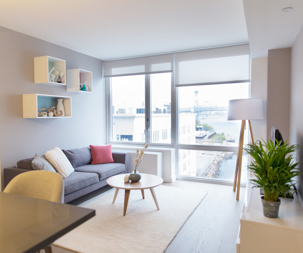 Photo of a small contemporary open plan living room in New York with grey walls and medium hardwood flooring.