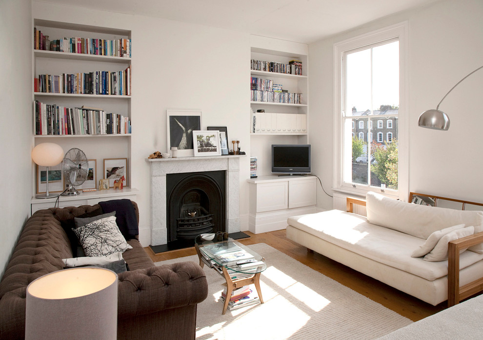 Exemple d'un salon moderne de taille moyenne et fermé avec un mur blanc, parquet clair, une cheminée standard, un manteau de cheminée en pierre et un téléviseur indépendant.