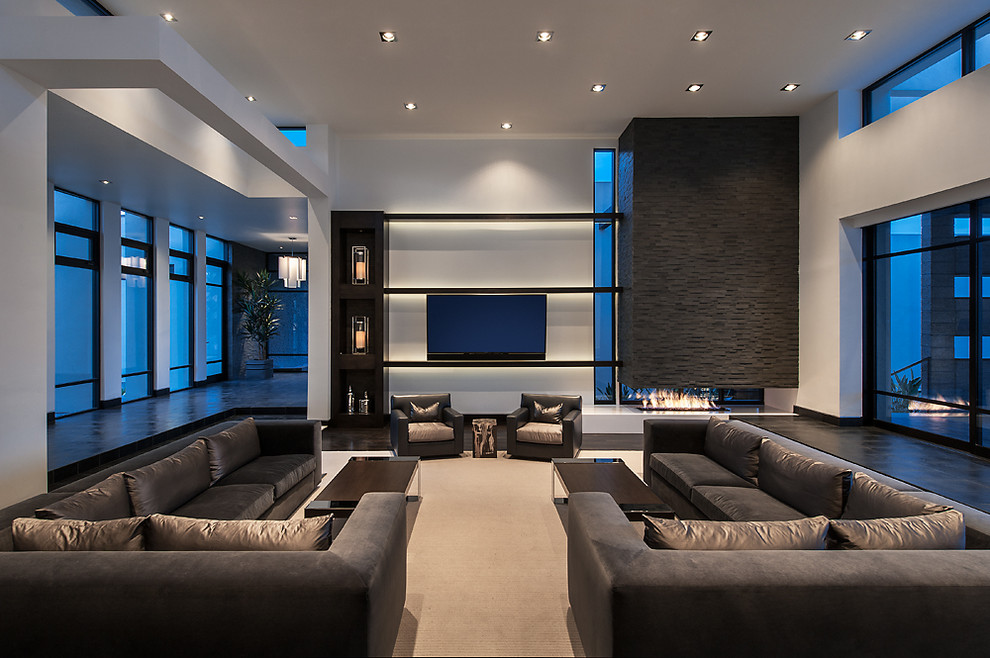 Ejemplo de salón para visitas abierto actual con paredes blancas, suelo de madera oscura, chimenea de doble cara y televisor colgado en la pared