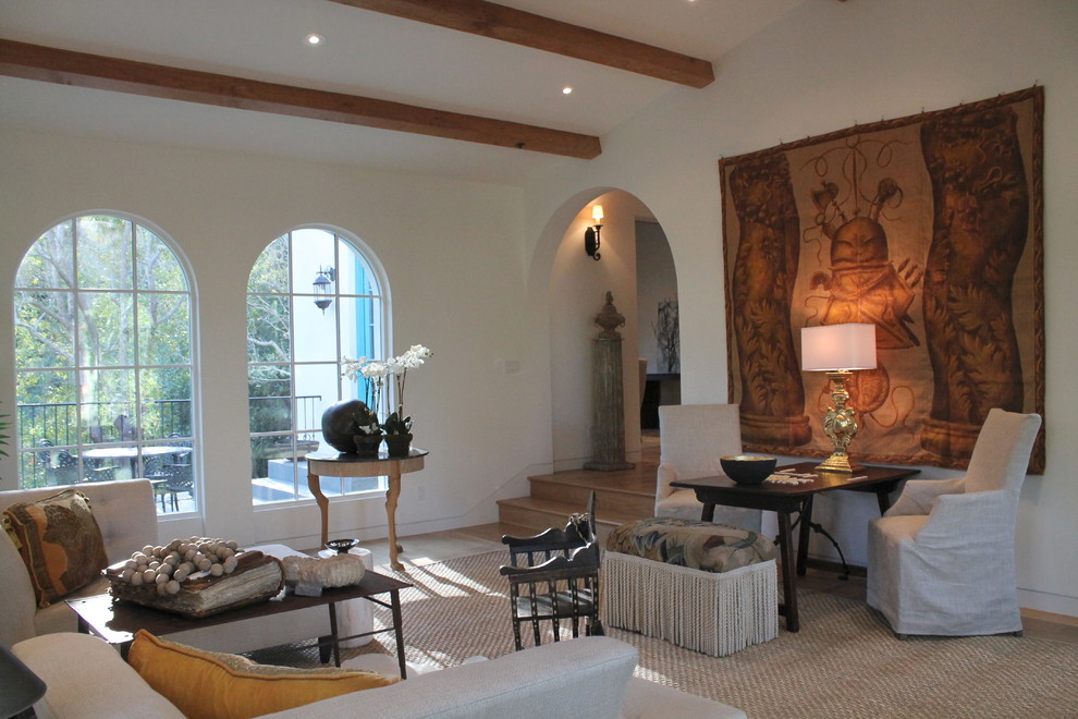 Ejemplo de salón para visitas cerrado mediterráneo de tamaño medio con paredes blancas, suelo de madera clara, todas las chimeneas y marco de chimenea de piedra