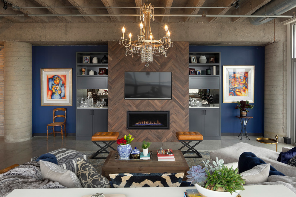 Diseño de salón con barra de bar tipo loft ecléctico grande con paredes azules, suelo de cemento, todas las chimeneas, marco de chimenea de baldosas y/o azulejos, pared multimedia y suelo gris