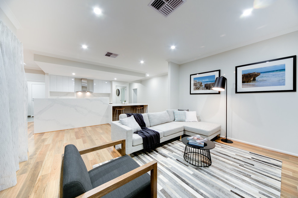Idee per un soggiorno minimal aperto con pareti grigie, parquet chiaro e pavimento beige