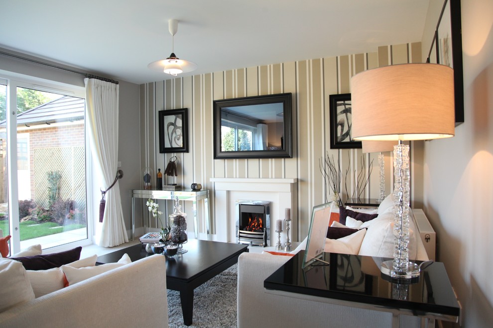 На фото: гостиная комната в современном стиле с ковровым покрытием, стандартным камином, фасадом камина из камня и телевизором на стене с
