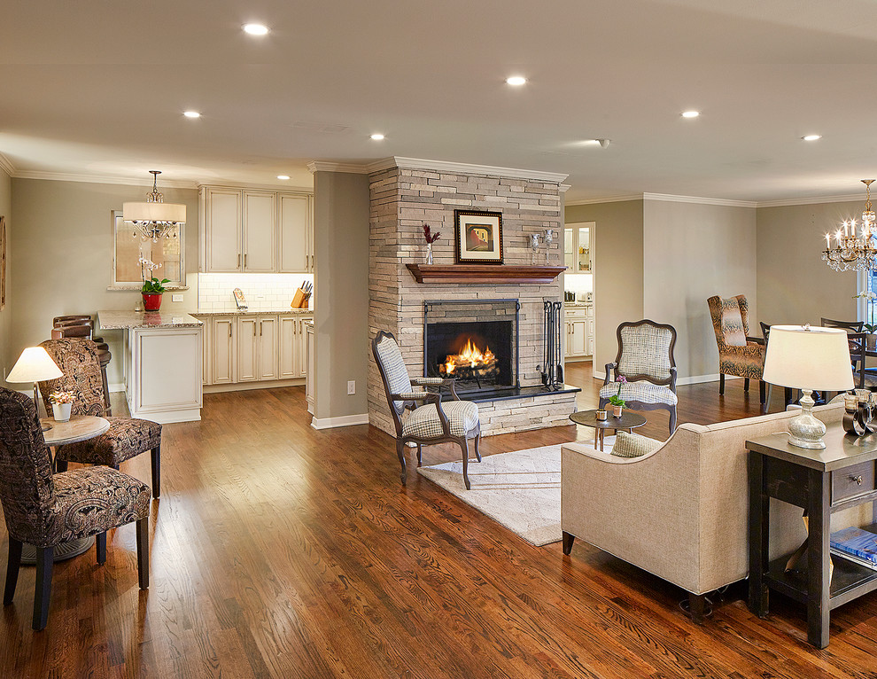 Elegant medium tone wood floor living room photo in Dallas with a standard fireplace and a stone fireplace