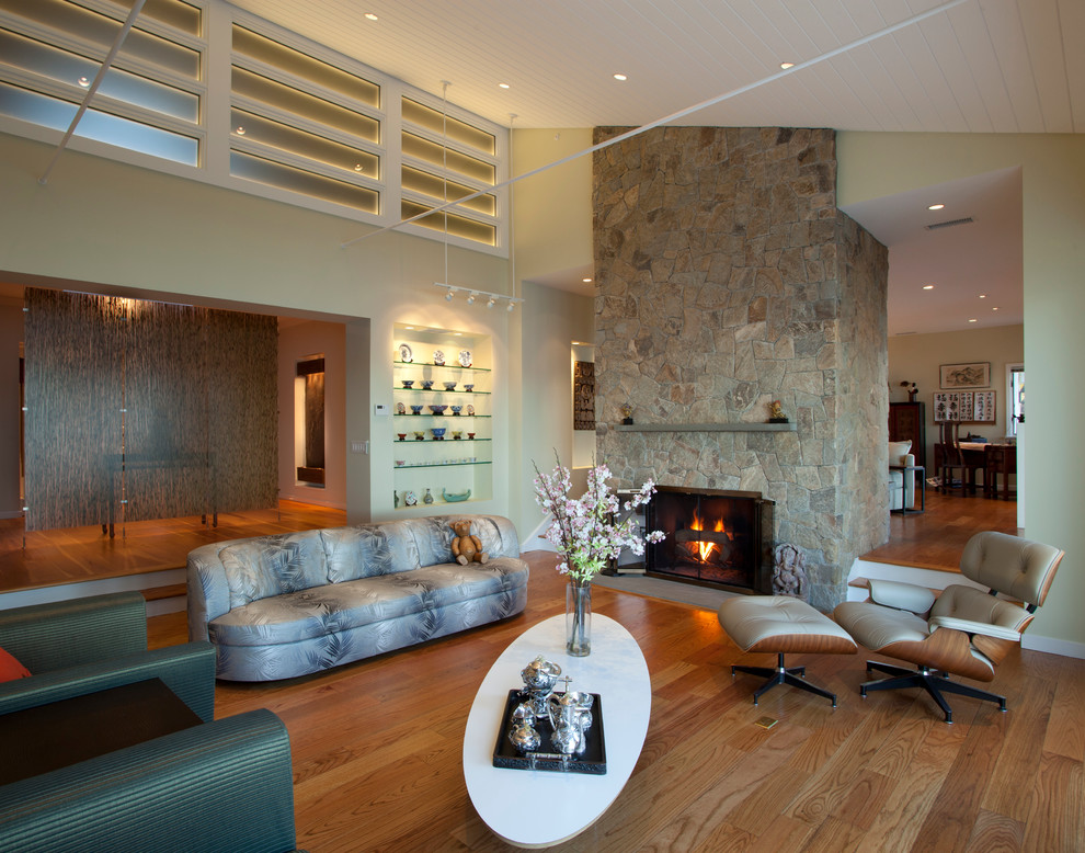 Стильный дизайн: гостиная комната в современном стиле с бежевыми стенами, стандартным камином и фасадом камина из камня - последний тренд