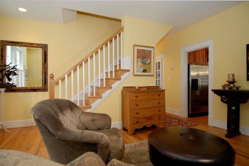На фото: открытая гостиная комната среднего размера в классическом стиле с желтыми стенами, паркетным полом среднего тона, стандартным камином, фасадом камина из кирпича и коричневым полом