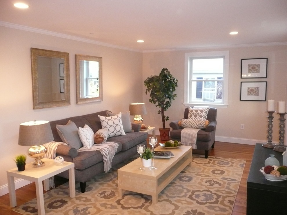 Immagine di un soggiorno classico di medie dimensioni e aperto con pareti beige, pavimento in legno massello medio, nessun camino e nessuna TV