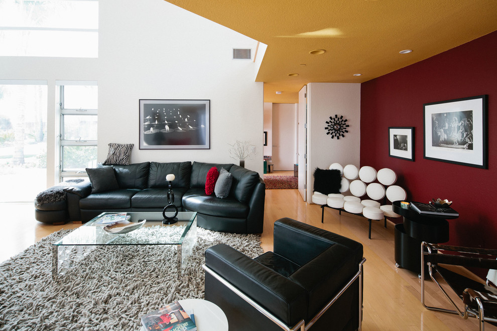 Idee per un soggiorno minimal di medie dimensioni e aperto con sala formale, pareti rosse e parquet chiaro