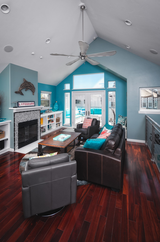 Photo of a medium sized nautical open plan living room in San Diego with blue walls, dark hardwood flooring, a standard fireplace, a tiled fireplace surround and a freestanding tv.