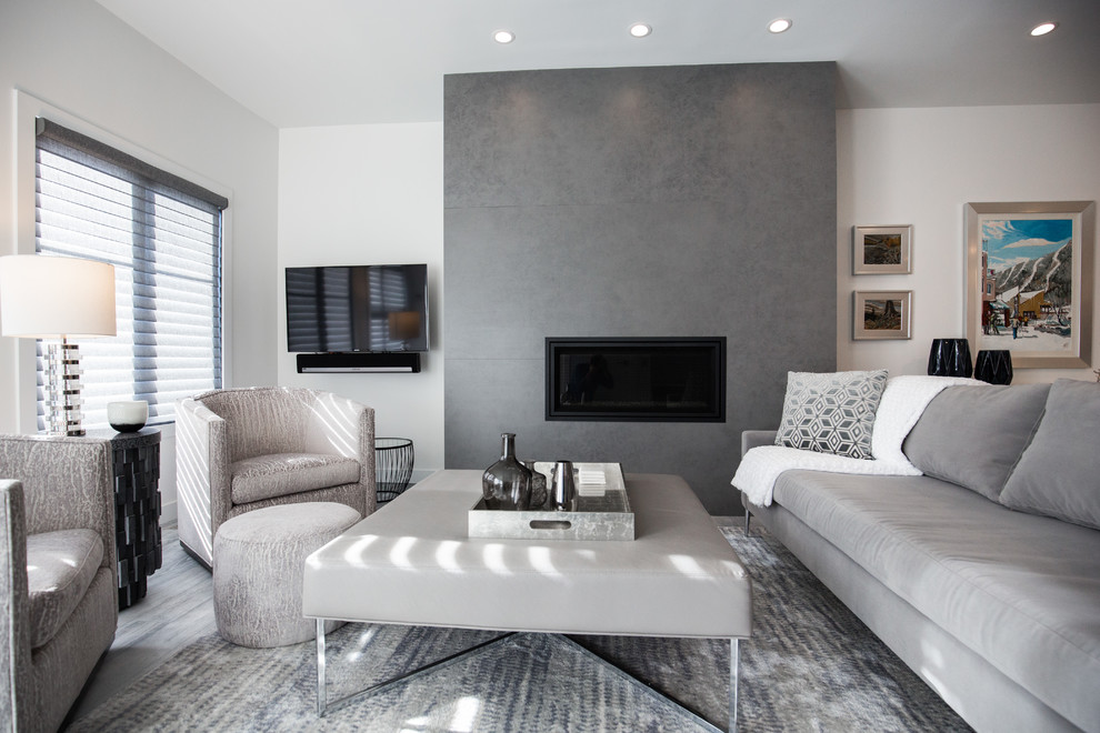 Immagine di un piccolo soggiorno minimalista aperto con pareti bianche, parquet chiaro, camino classico, cornice del camino piastrellata, TV a parete e pavimento grigio