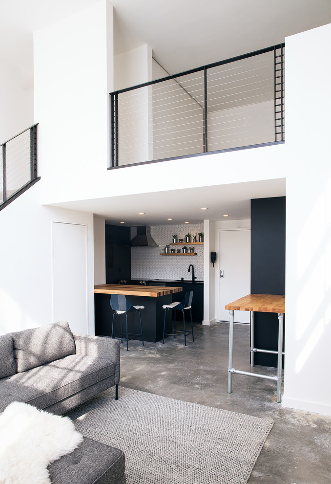 Small contemporary mezzanine living room in San Francisco with white walls, concrete flooring and grey floors.