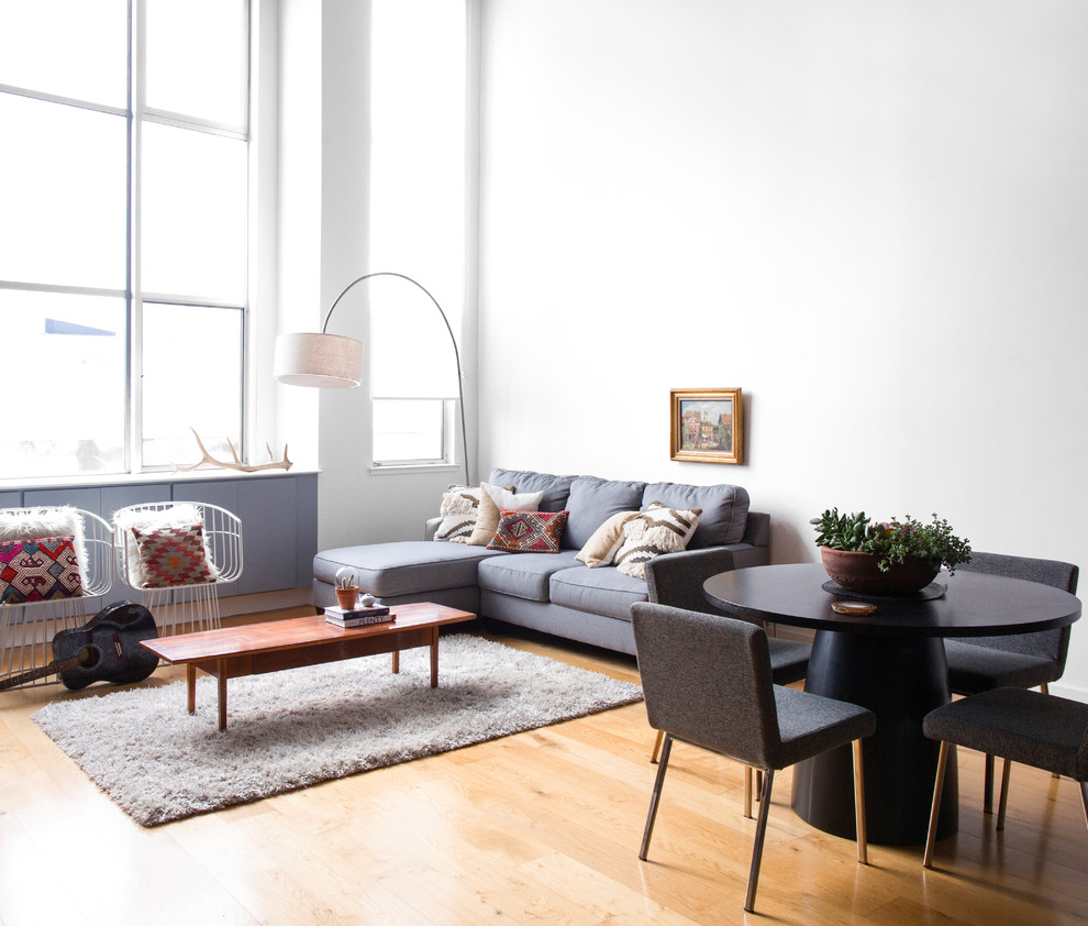 Design ideas for a large scandi open plan living room in New York with white walls, light hardwood flooring, a standard fireplace, a metal fireplace surround and beige floors.