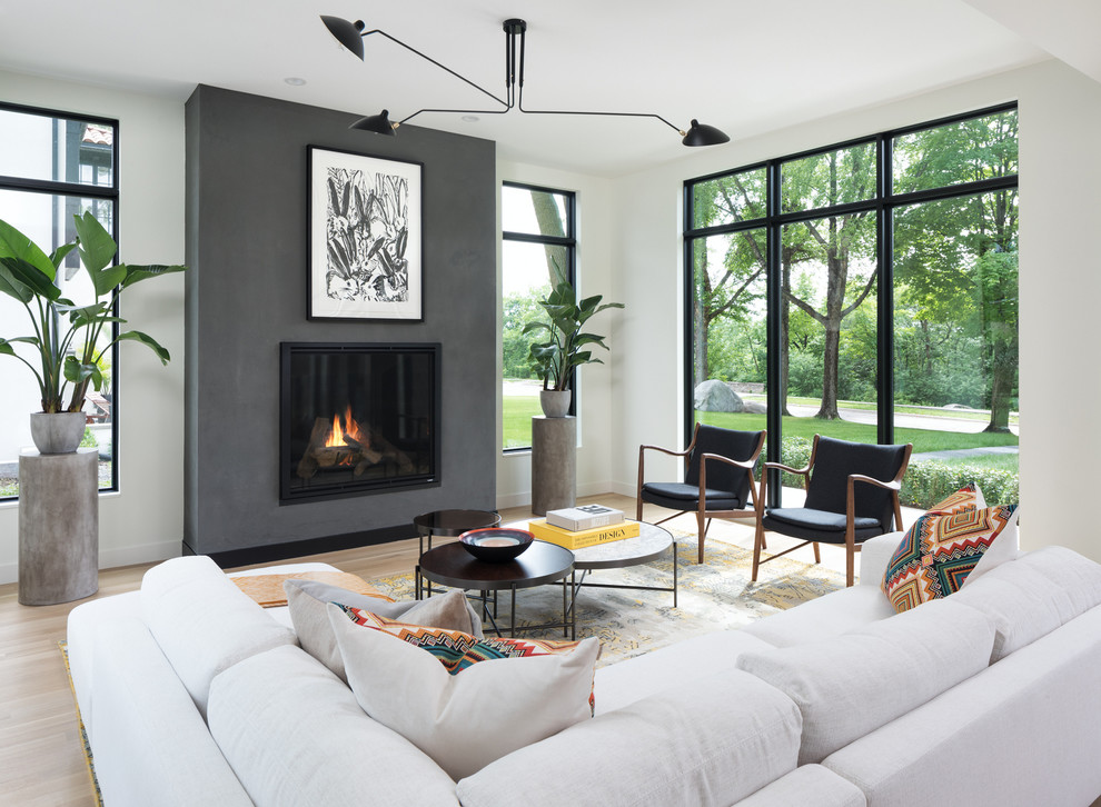 Contemporary open plan living room in Minneapolis with white walls, light hardwood flooring, a standard fireplace, no tv and beige floors.